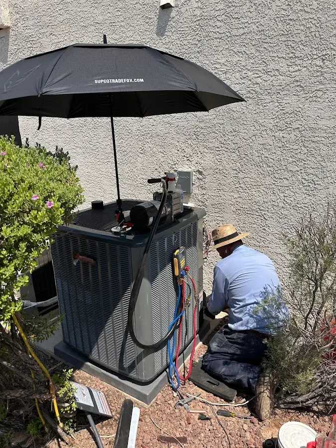HVAC technician performing outdoor AC maintenance in Farmington